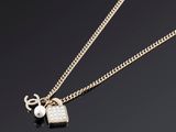 un collier en or orné d'un cadenas et d'une perle