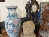 trois vases posés sur une table sur laquelle se trouve une horloge