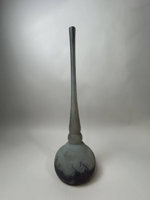 un vase noir et blanc posé sur une surface blanche