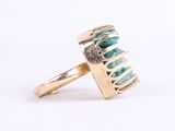 a close up of a gold ring with a turquoise stone in it
