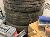 une femme qui travaille sur un ordinateur portable près d'un tas de pneus