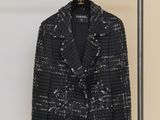 a black and white jacket hanging on a rack in front of a wall
