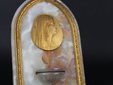 plaque en marbre doré et blanc représentant un homme coiffé d'un chapeau