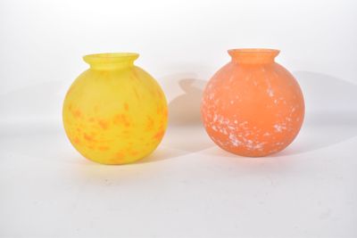 des vases jaunes et orange posés côte à côte sur une surface blanche