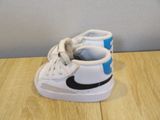 a pair of white and blue sneakers on a wooden table