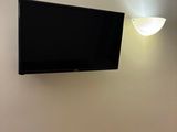 une télévision à écran plat fixée au mur au-dessus d'un lit