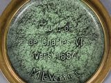 a close up of a gold plate with a picture on it