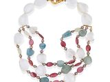 un gros plan d'un collier composé de perles multicolores sur fond blanc