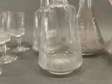 bottles and glasses are lined up on a table next to each other