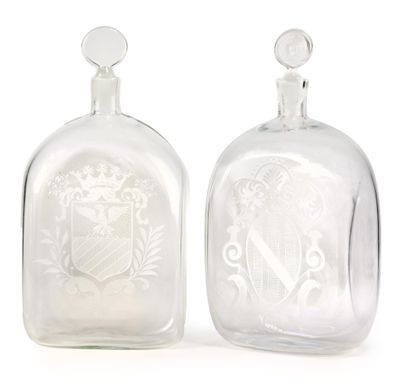 une paire de bouteilles en verre transparent ornées d'un blason gravé