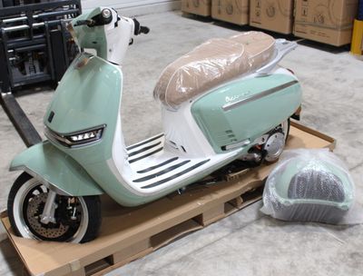 un scooter posé sur une palette dans un entrepôt