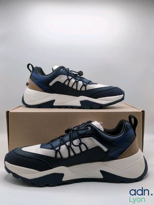 a pair of blue and white sneakers sitting on top of a box