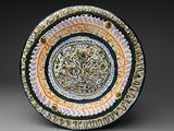 une assiette colorée ornée d'un motif sur un fond gris