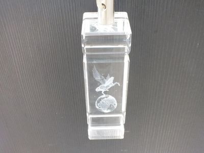 a clear glass vase with a silver bird on it