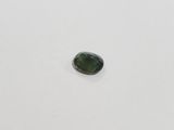 a green tourmaline stone on a white surface