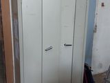 une armoire métallique au milieu d'une pièce, sur laquelle sont posées des boîtes