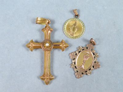 deux croix dorées et une médaille sur un fond blanc