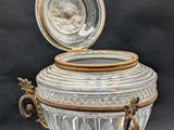 an antique silver and cut glass urn with a lid on a stand