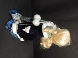 a doll that is laying down on a black surface
