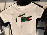a t - shirt with a crocodile on it hanging on a rack