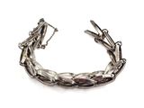 a close up of a silver bracelet on a white background