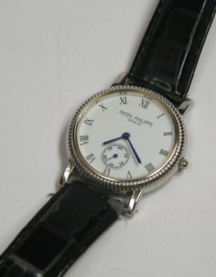 a close up of a wrist watch on a white surface