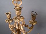 a gold plated chandelier with four candles on it