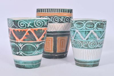 three cups sitting next to each other on a white surface