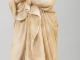 marble statue of a woman holding a baby on a wooden table