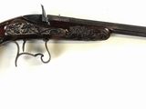 an old gun with a wooden handle on a white surface