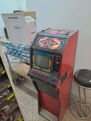 une borne d'arcade rouge et noire dans un coin de la pièce