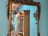 a mirror hanging on the wall above a cabinet