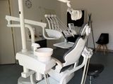a dentist ' s chair in the middle of a room with a clock on the wall