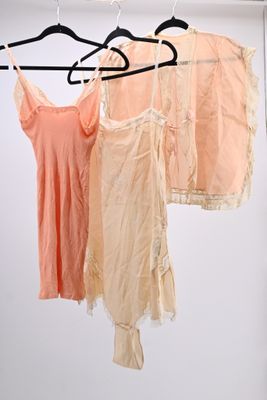 three shirts hanging on a clothes rack in a room