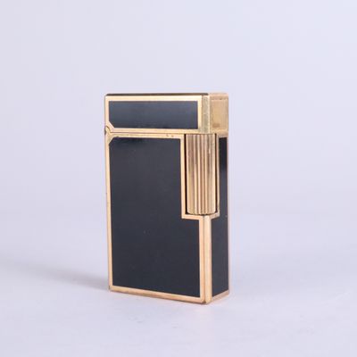 a close up of a black and gold lighter on a white background