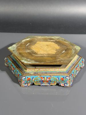 une assiette en or ornée d'un motif bleu et rouge