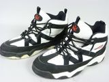 une paire de baskets noires et blanches avec des touches de rouge sur un fond blanc