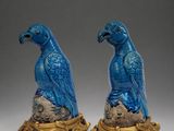 pair of blue and gold figurines of two birds sitting on a branch