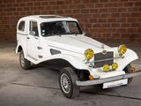 a white jeep parked in front of a brick wall