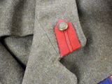 a close up of a jacket with a red button on it