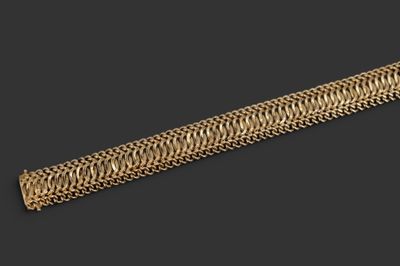 gros plan d'un bracelet en or sur fond noir