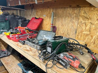 many tools on a wooden shelf in a garage