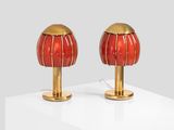 pair of red and gold table lamps on a white surface