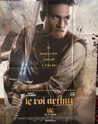 une affiche de film représentant un homme tenant une épée devant un mur