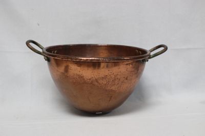 une vieille casserole en cuivre avec des anses, sur fond blanc