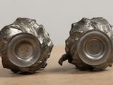 two silver vases sitting on a wooden table