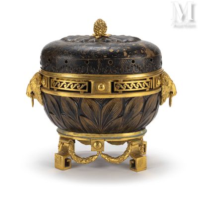 une boîte noire et dorée posée sur un socle, sur fond blanc