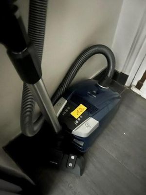 un aspirateur posé sur le sol à côté d'une chaise