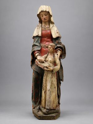 une statue ancienne d'une femme tenant un bébé dans ses bras