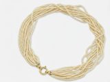 a close up of a necklace with pearls on a white background